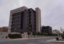 Parole Decision Sparks Outrage Over The Case Modern concrete and dark glass government building on a cloudy day