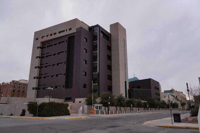 shutterstock_2253767651 Modern concrete and dark glass government building on a cloudy day