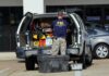 FBI evidence technician working at the open back of an SUV