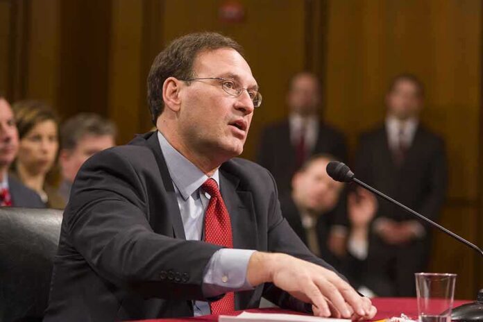 Samuel Alito speaking into a microphone at a hearing