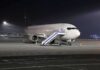 Passengers and Pilots Step In During Cockpit Crisis Passenger airplane parked on tarmac at night with mobile stairs